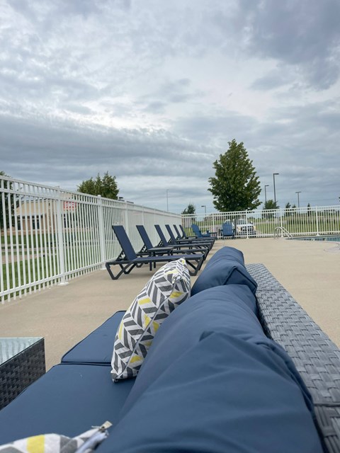 A row of blue sun loungers are on a patio.