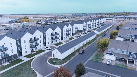 A row of modern houses with cars parked in front.