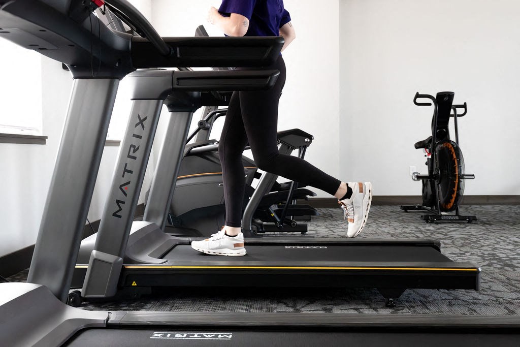 a woman running on a treadmill in a gym