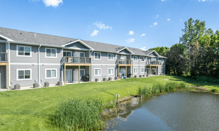 A row of houses with a pond in front.