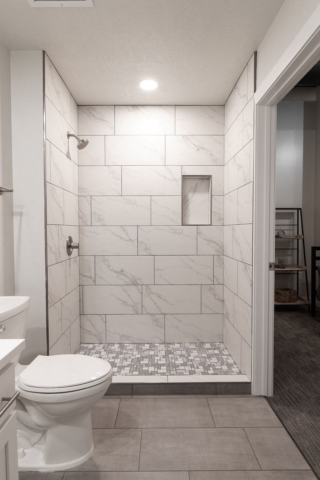 a bathroom with a tiled shower and a toilet