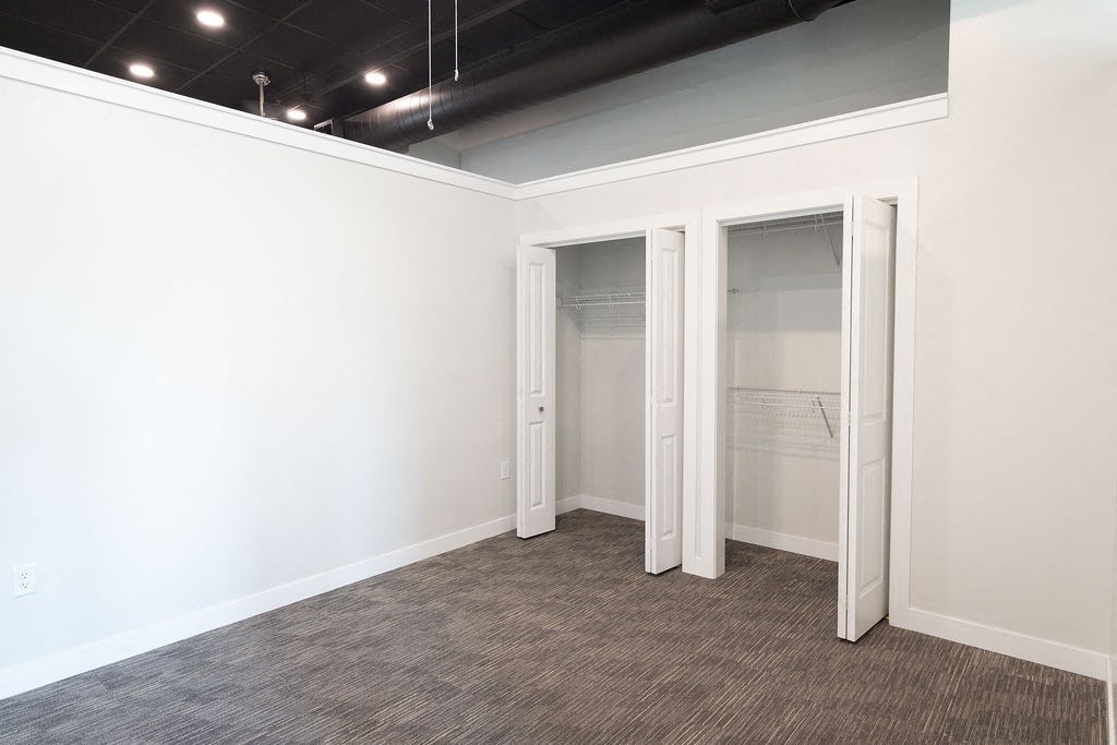 a room with white walls and a closet with doors