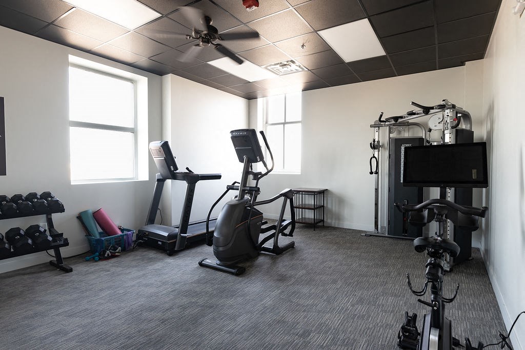 a home gym with exercise equipment and a tv