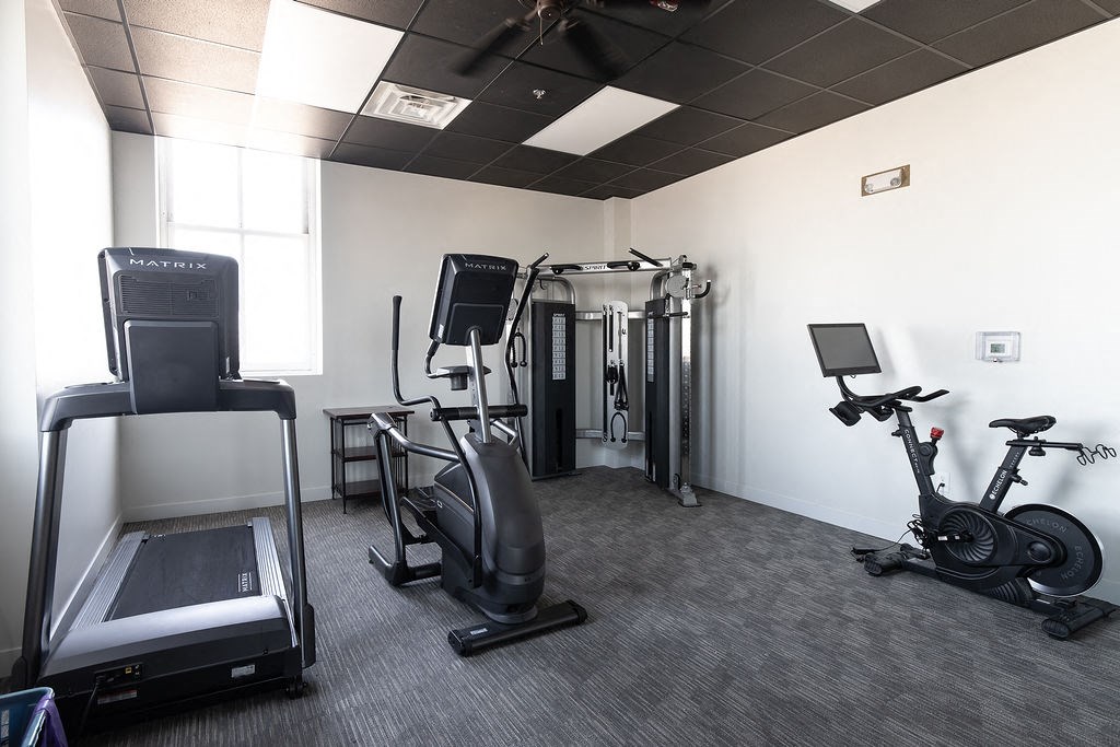 a gym with various machines and weights in a room