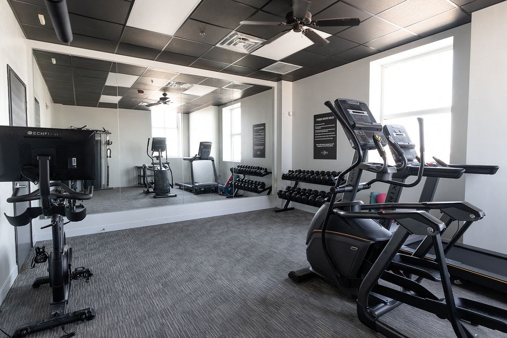 a gym with treadmills and other exercise equipment in a building