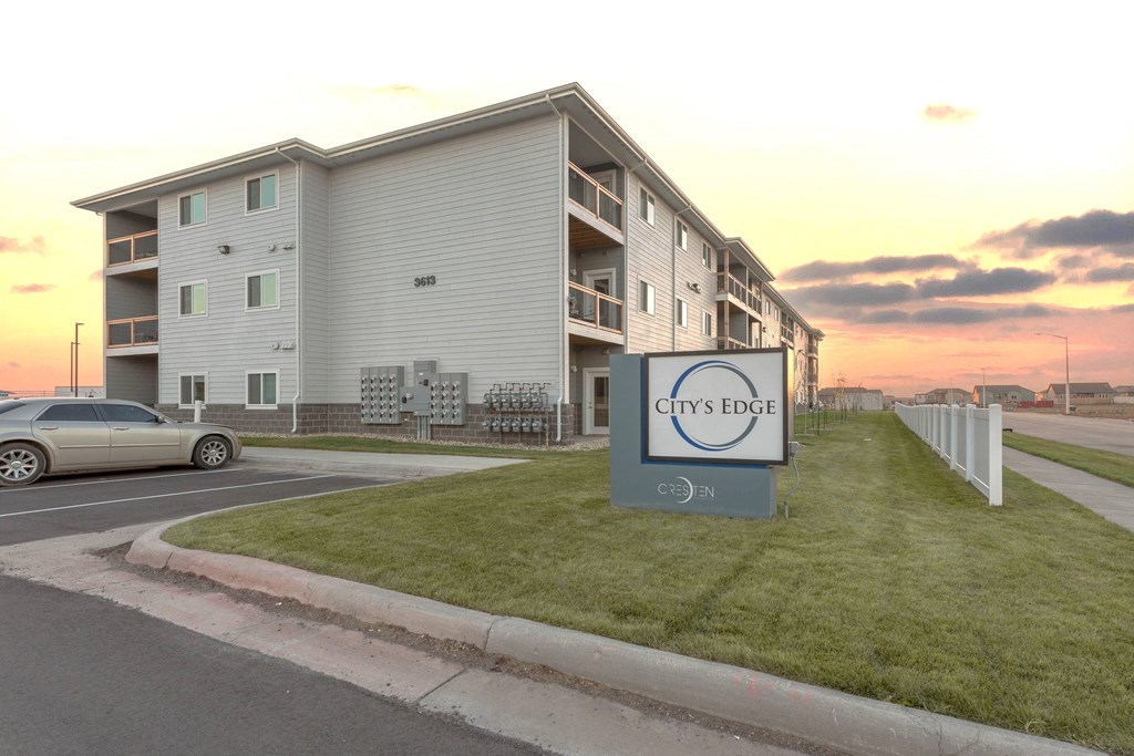 an apartment complex with a car parked in front of it