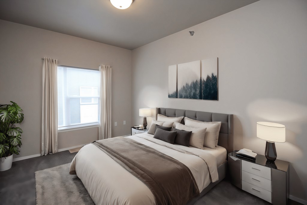 A bedroom with a large bed, a nightstand with a lamp, and a painting on the wall.