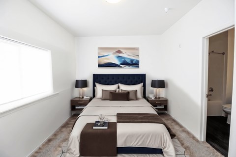 A bedroom with a large bed and a painting on the wall.