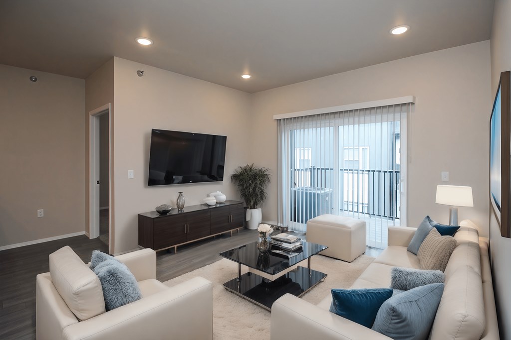 A living room with a white couch and a black coffee table.