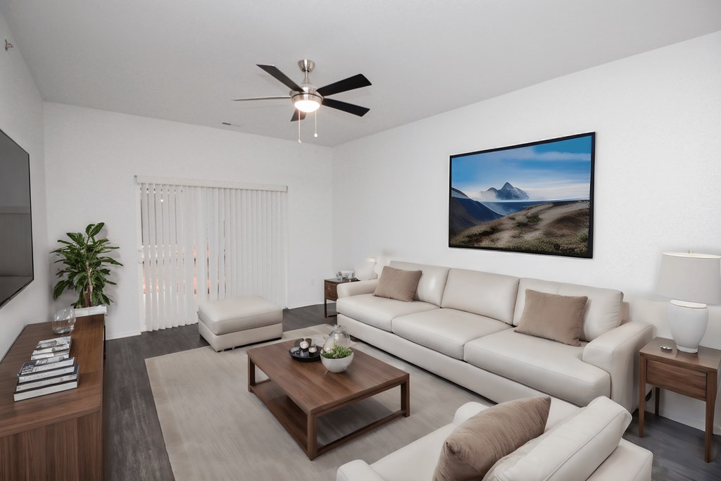 A living room with a large painting of a mountain landscape on the wall.