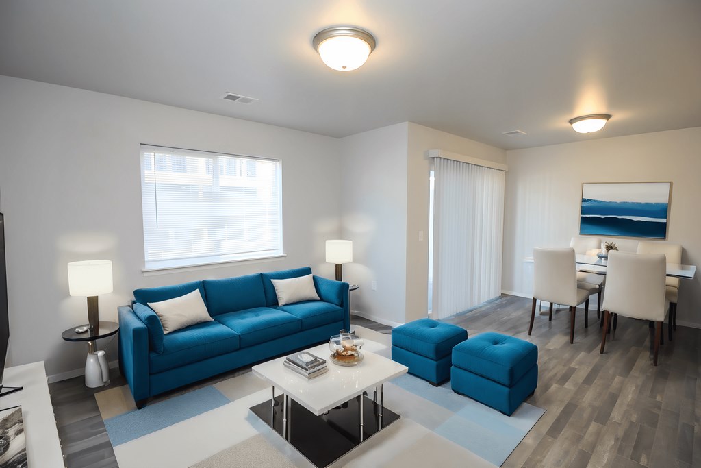 A living room with a blue couch and a white coffee table.
