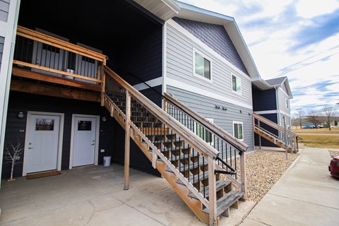 A house with a grey siding and a white door is shown.