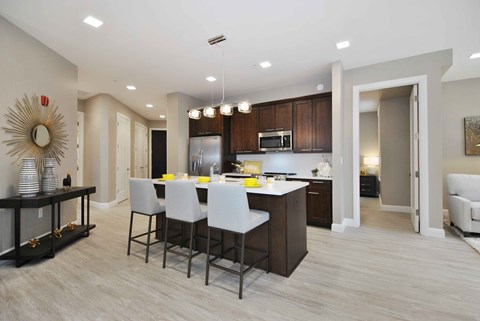 a kitchen with a large island and white chairs