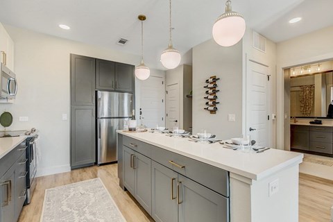 A kitchen with a white counter top and a stainless steel refrigerator.