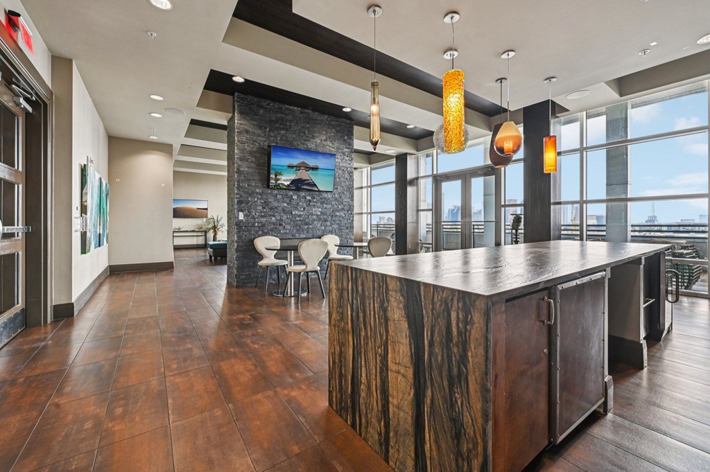 A modern bar area with a stone wall and wooden bar.