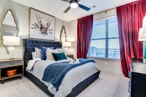 A bedroom with a large bed and a deer head on the wall.