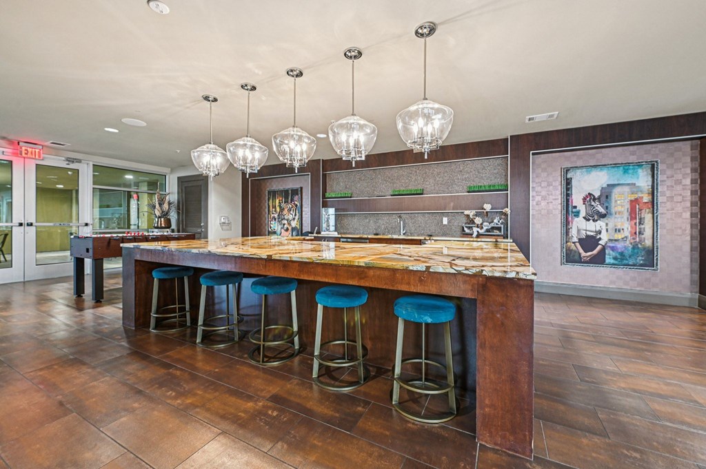 A bar with blue stools and a wooden counter.
