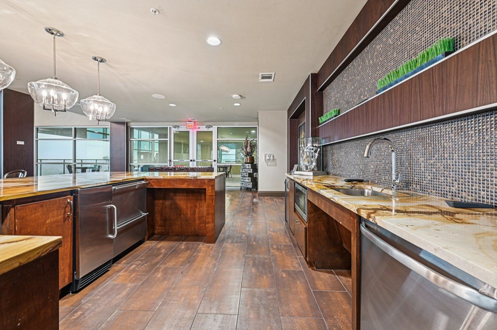 A modern kitchen with wooden floors and stainless steel appliances.