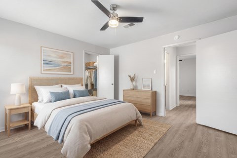 A bedroom with a large bed and a ceiling fan.
