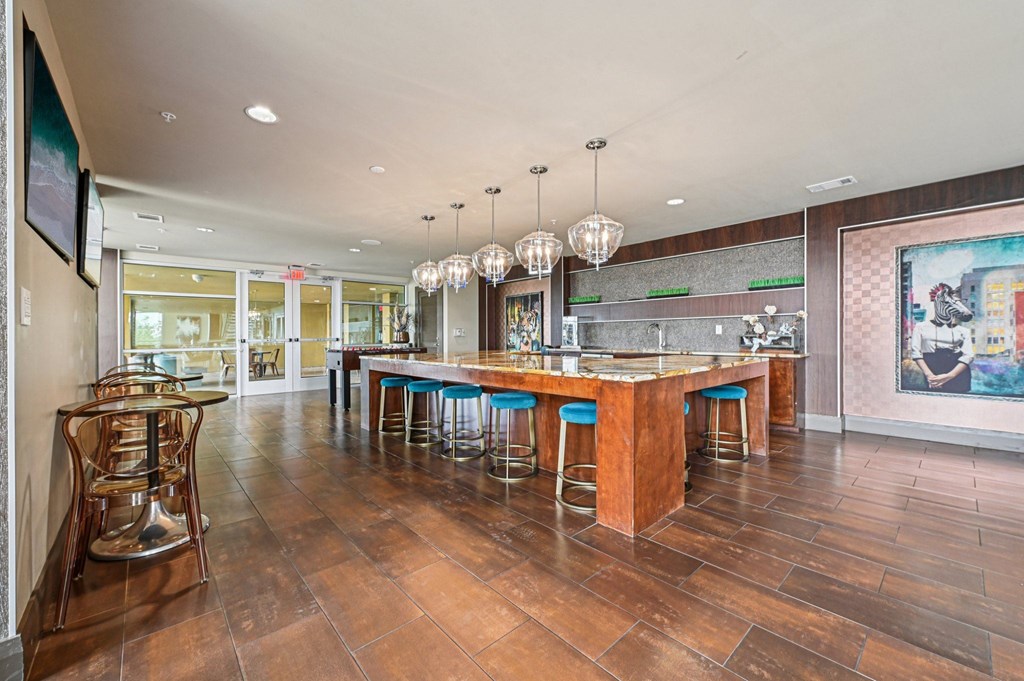 A bar area with a wooden counter and blue stools.