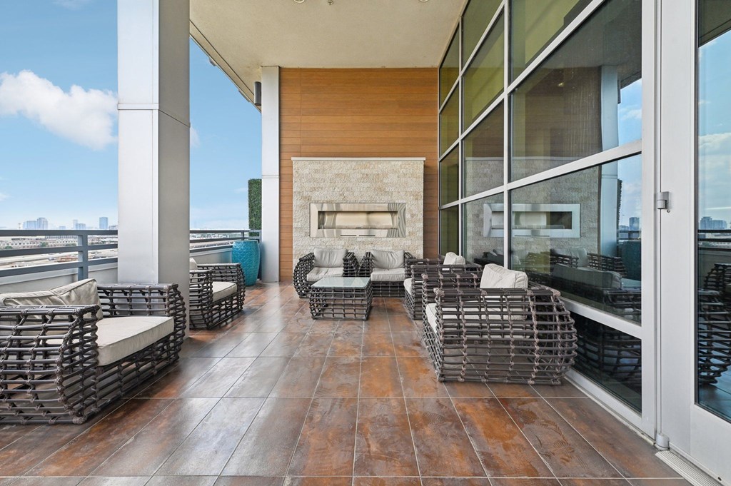 A patio with a fireplace and chairs.