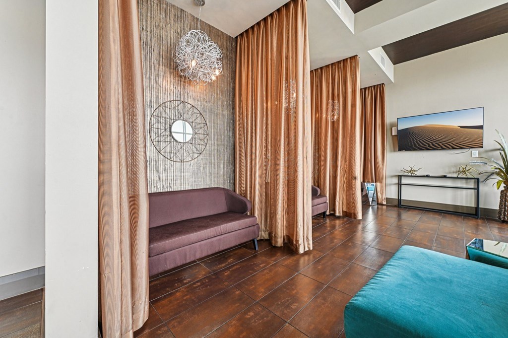 A living room with a purple couch and a blue ottoman.