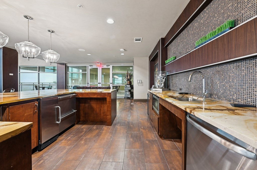 A modern kitchen with wooden floors and stainless steel appliances.