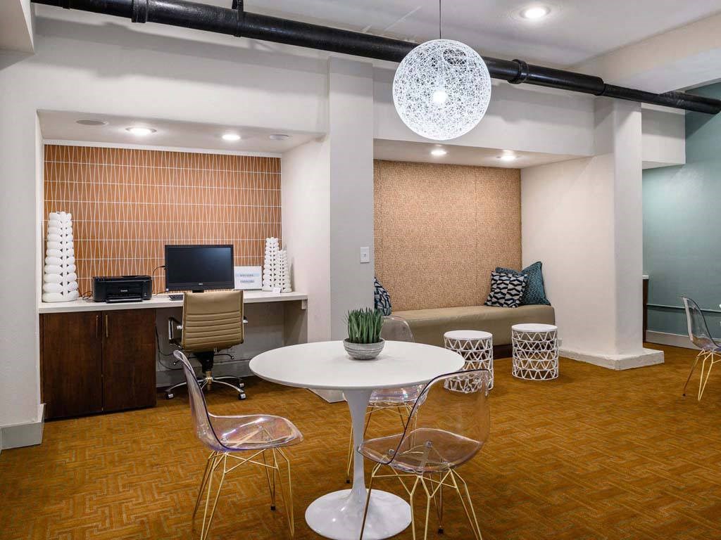 Business center with computers and arm chairs. A table with chairs at Memorial Towers Apartments, The Barvin Group, Houston, Texas