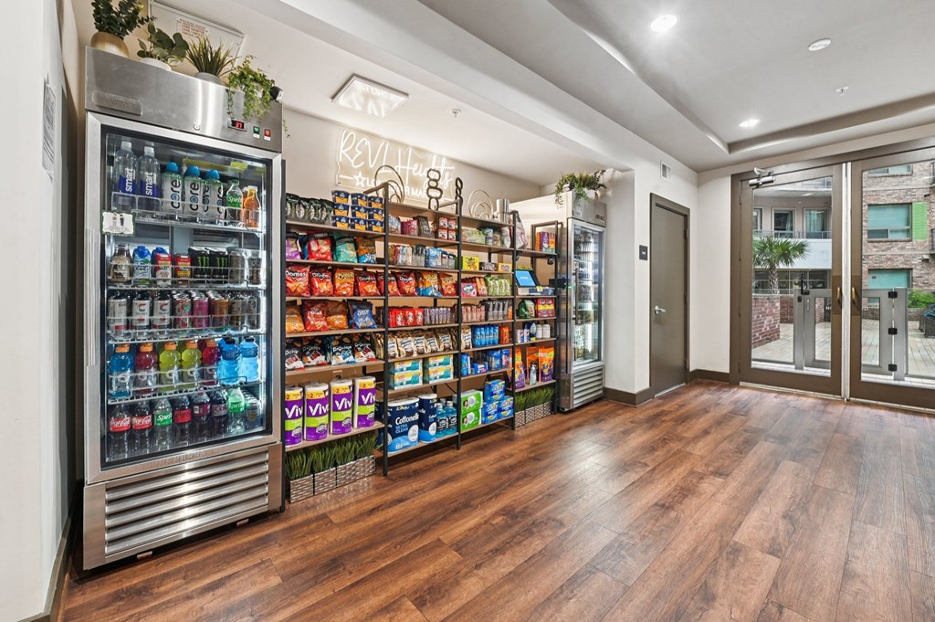 A well-lit room with a large refrigerator and a wooden floor.