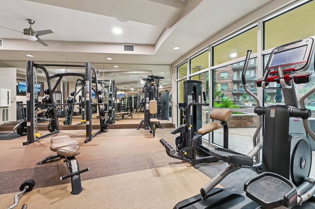 A gym with a variety of cardio equipment including treadmills, weights, and exercise machines.