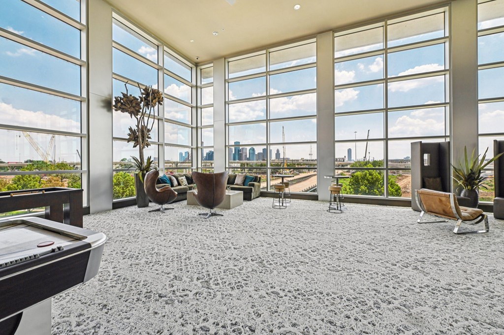 A room with a pool table and a view of the city.