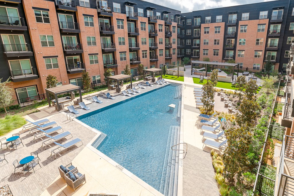 an aerial view of a swimming pool in front of an apartment building