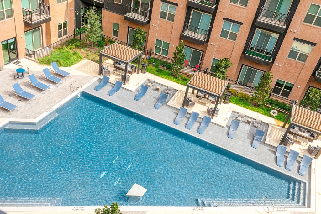an aerial view of a swimming pool in front of an apartment building