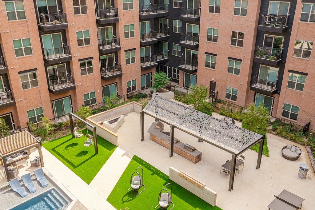 an aerial view of the courtyard of an apartment building with a pool and picnic table