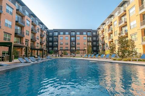 A swimming pool in front of apartment buildings.