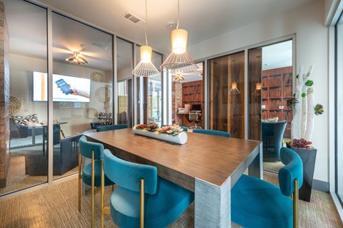 A modern dining room with a wooden table and blue chairs.