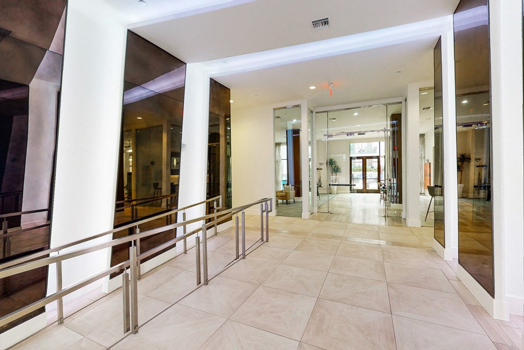 A hallway with a tiled floor and a glass wall.