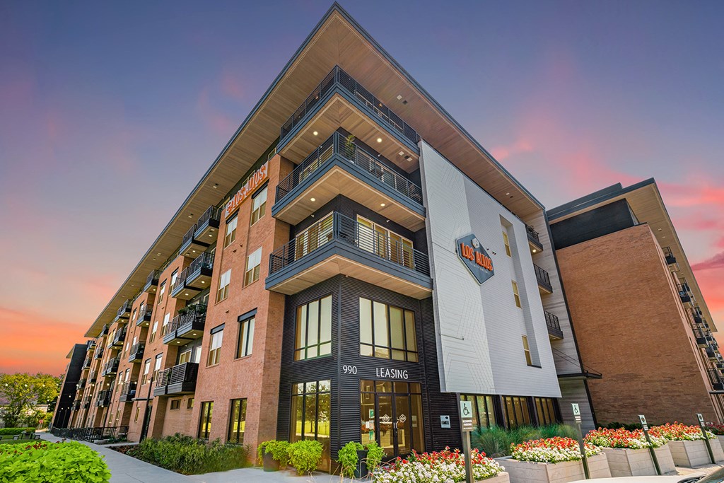 a rendering of an apartment building with a sunset in the background