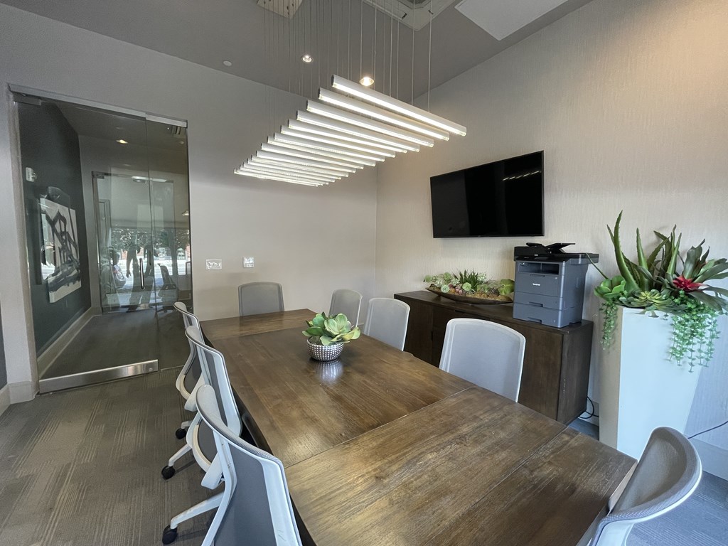 A conference room with a long table and chairs.