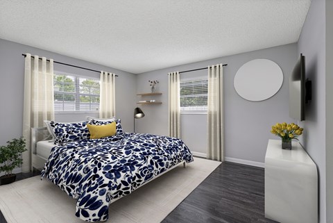 A bedroom with a large bed and a TV on the wall.