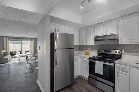 A modern kitchen with a stainless steel refrigerator and oven.