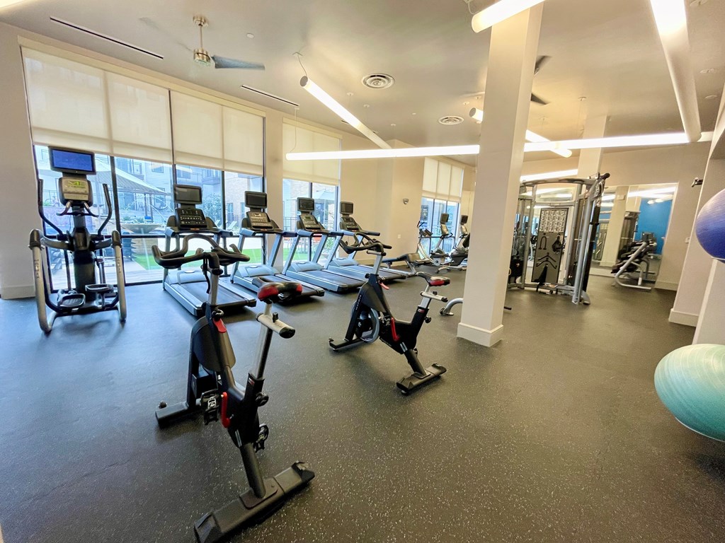 A gym with exercise equipment and a ball.