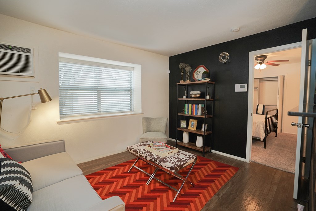 a living room with a couch and a coffee table in front of a bookshelf