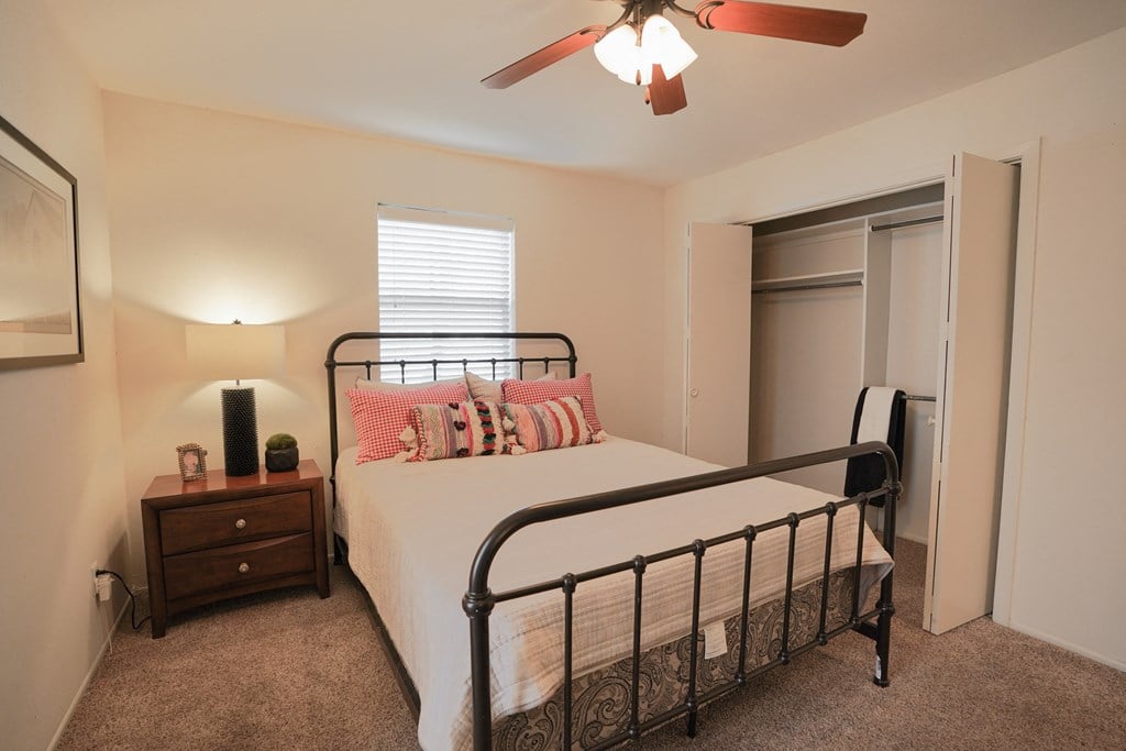 a bedroom with a bed and a ceiling fan