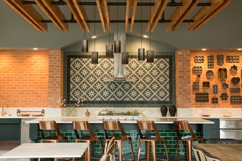 A kitchen with a white counter top and green tiles.