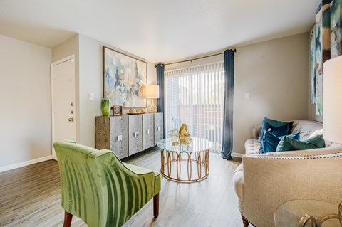 A living room with a green chair and a white couch.