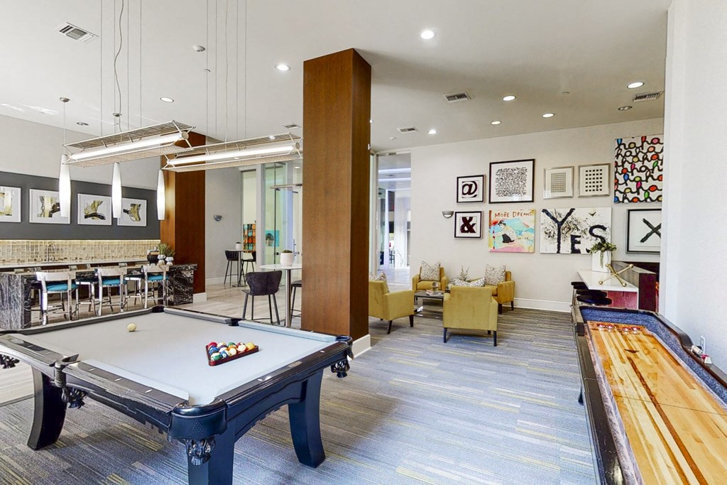 A room with a pool table and a shuffleboard table.