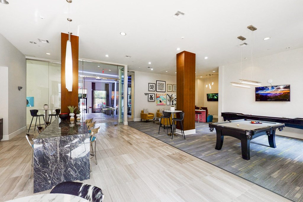 A room with a pool table and a bar.