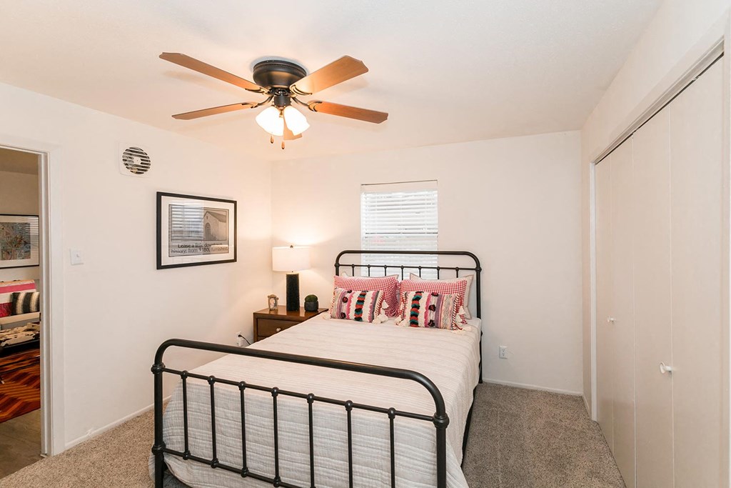 a bedroom with a bed and a ceiling fan