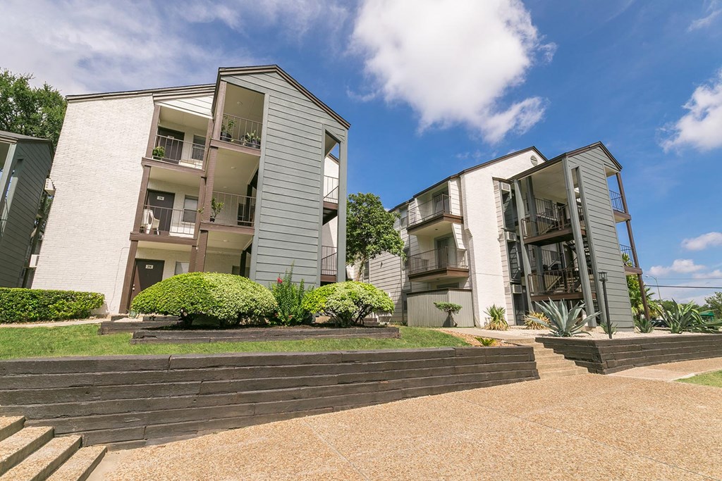 a picture of two apartment buildings with a blue sky in the background